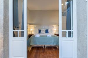 ポルトにあるAPorTo - 2 Suitesのベッドルーム1室(青いシーツとランプ2つ付)