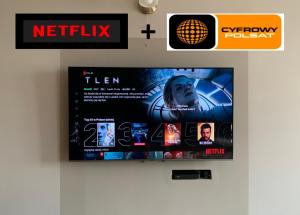 a tv hanging on a wall with anetflix sign at Apartamenty nad jeziorem in Ełk