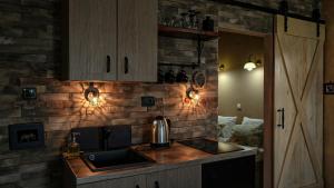 a kitchen with a sink and a brick wall at Dunavska Kuća in Smederevo
