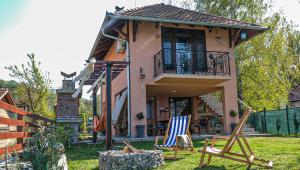 a house with two lawn chairs in the yard at Dunavska Kuća in Smederevo