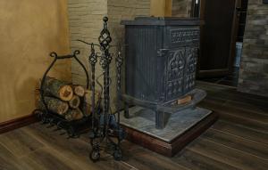 a wood stove in a room with a basket of logs at Dunavska Kuća in Smederevo