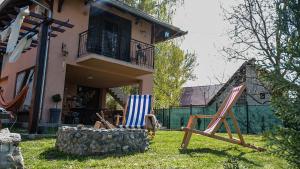 two lawn chairs sitting in the grass in front of a house at Dunavska Kuća in Smederevo
