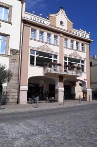 a large building with a balcony on the side of it at Penzion Hotelu Central in Dvůr Králové nad Labem