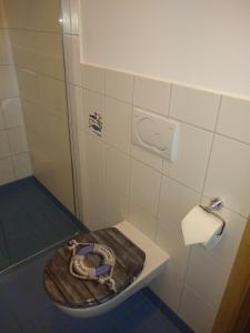 a bathroom with a toilet with a wooden seat at Ferienwohnung Amende in Angermünde