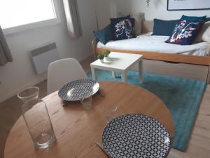 a living room with a table and a bed at Le cosy de Saint Jean in Saint-Jean