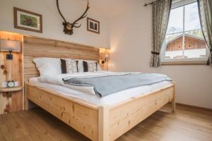 Schlafzimmer mit einem Bett mit einem Kopfteil aus Holz in der Unterkunft Ferienwohnungen Villa Salzweg in Bad Goisern
