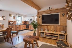 a living room with a television on a wooden wall at Ferienwohnungen Villa Salzweg in Bad Goisern