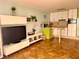 sala de estar con TV grande y cocina en El Paraiso, en Estepona