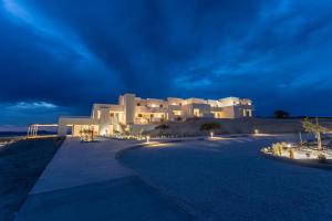 a large white building on the beach at night at Domes White Coast Milos, Adults Only - Small Luxury Hotels of the World in Mytakas
