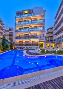 a swimming pool in front of a building at Leonidas Hotel & Apartments in Rethymno