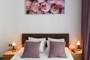 a bedroom with a bed with pink roses on the wall at Ally by the Sea & SPA- cu parcare privata-in Alezzi Beach Resort in Mamaia Nord +78 photos