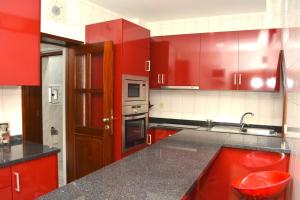 a kitchen with red cabinets and a black counter top at Casa do Mirante in Porto