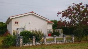 uma casa branca com uma cerca à frente. em Le Soleil en Gironde em Vrillant