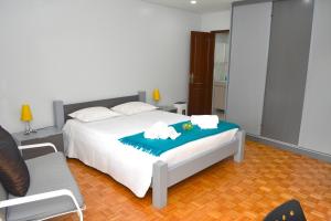 a bedroom with a bed with a blue blanket at Casa do Mirante in Porto