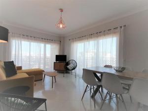 - un salon avec une table, des chaises et un canapé dans l'établissement All Seasons Beach Apartment Espirito Santo, à Portimão