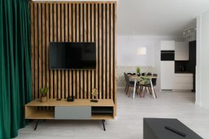 salon z telewizorem na drewnianej ścianie w obiekcie Apartamenty Forest - Nadmorskie Tarasy D409 w Kołobrzegu