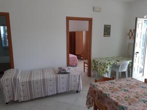 una camera con due letti, un tavolo e uno specchio di Appartamenti Procenisco a Peschici