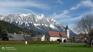ÖblarnSonnendorf Öblarn的一座教堂,位于雪覆盖的山前