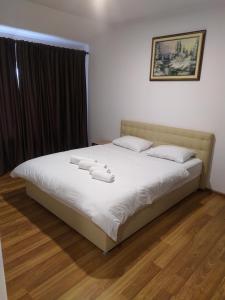 a bedroom with a bed with white sheets and pillows at Mirage in Chernivtsi