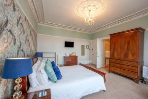 a bedroom with a bed and a chandelier at Hawthornbank in Oban