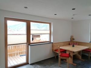 ein Esszimmer mit einem Tisch und einem Fenster in der Unterkunft Apart Paul in Nauders