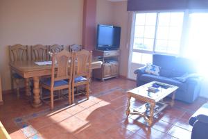 a living room with a dining table and a television at Pensión o noso bar in Portosin