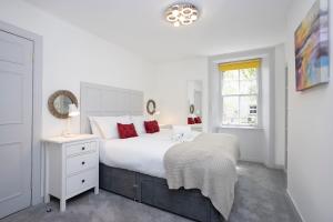 a white bedroom with a large bed and a window at ALTIDO Elegant New Town Flat near Princes Street in Edinburgh