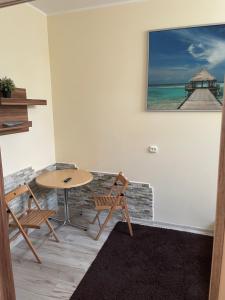 een tafel en stoelen in een kamer met een foto van een pier bij Hostel4u in Gdańsk