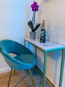 uma cadeira azul sentada ao lado de uma mesa com copos de vinho em B&B Numero5 em Castellammare di Stabia