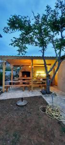 a pavilion with a tree in front of it at Apartmani Nikica in Drage