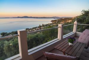 a balcony with chairs and a view of the water at Barbati breathtaking views in Barbati