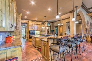 una gran cocina con armarios de madera y una isla con sillas en Private Dock and Water Views Hot Springs Abode!, en Hot Springs