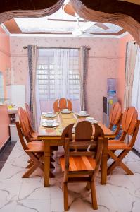 comedor con mesa de madera y sillas en Dondoo's Paradise- Perfect Vacation Home en Kilifi