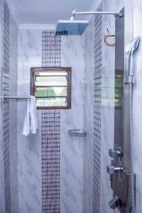 baño con ducha y puerta de cristal en Dondoo's Paradise- Perfect Vacation Home en Kilifi