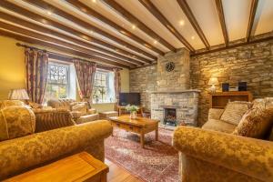 a living room with couches and a stone fireplace at Theaked Stones in Leyburn