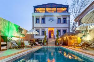 a house with a swimming pool in front of a house at Parna Hotel in Cunda