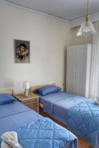 a bedroom with two beds and a picture on the wall at Liana`s apartment in Paleo Tsifliki
