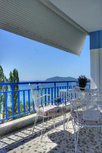 a table and chairs on a balcony with a view of the ocean at Liana`s apartment in Paleo Tsifliki