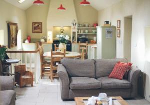 a living room with a couch and a kitchen at Scott's Barn in Cookstown