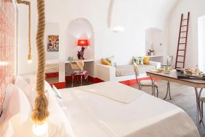 Cette chambre blanche comprend un lit, une table et un bureau. dans l'établissement Casa al Sole Boutique Hotel, à Ischia