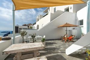 a patio with a table and an umbrella at Akron Cliff Suite in Fira