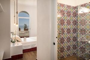 a bathroom with a shower with a tile wall at Casa al Sole Boutique Hotel in Ischia