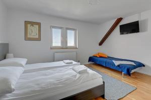 Dieses weiße Zimmer verfügt über 2 Betten und einen TV. in der Unterkunft Grand Apartments - Baltic Attic Classic Loft in Sopot in Sopot