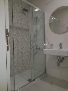W łazience znajduje się szklana kabina prysznicowa i umywalka. w obiekcie Apartman VIVO city central w mieście Podgorica