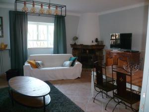 a living room with a white couch and a table at bastide St Joseph in Eyguières