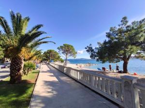 a sidewalk next to a beach with people on it at Ivana apartman 3 in Crikvenica