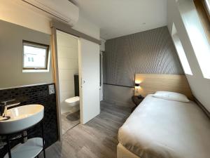 a hotel room with a toilet, sink, and bathtub at Hotel de Saint-Germain in Paris