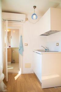 a kitchen with white cabinets and a sink at Casa Calle del Forno in Grado