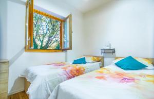 zwei Betten in einem Zimmer mit Fenster in der Unterkunft Dalmatian Green Peak in Slime