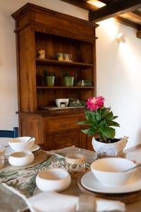 a table with bowls and plates and a flower on it at Acqua di Civita Beauty & Rooms in Mercatello in Bagnoregio